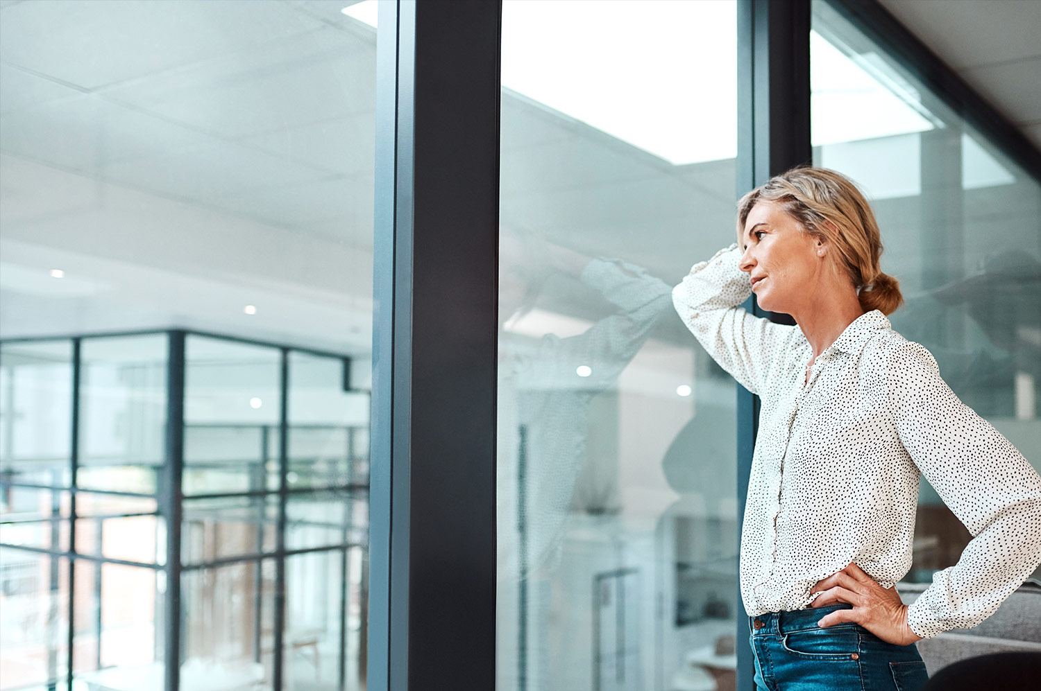 A businesswoman looks worriedly out a window