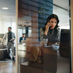 Woman in a cubicle at the phone in her office
